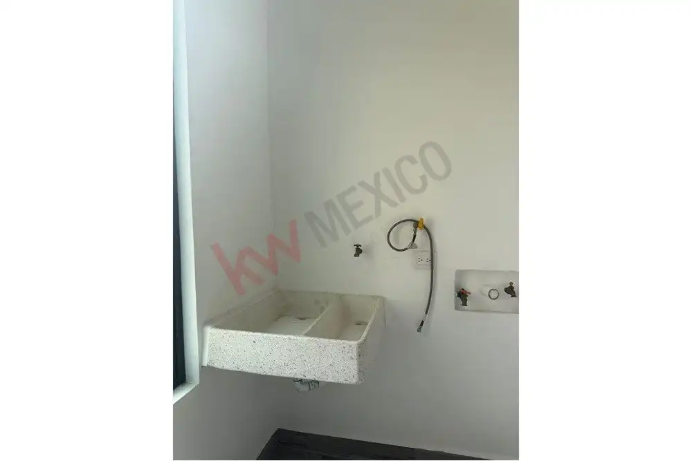 Bright laundry area with utility sink and plumbing in Arcos de San Miguel.
