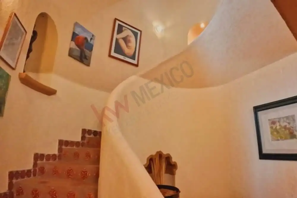Elegant interior staircase with artistic wall decor in a modern home.