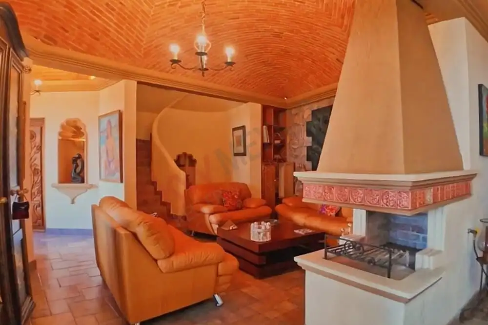 Interior view of a warm living room with fireplace and comfortable seating in San Miguel de Allende.