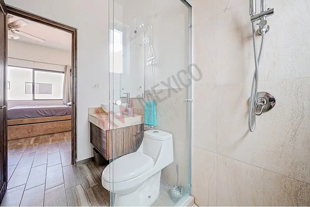 Bright bathroom with walk-in shower and modern fixtures in a stylish home.
