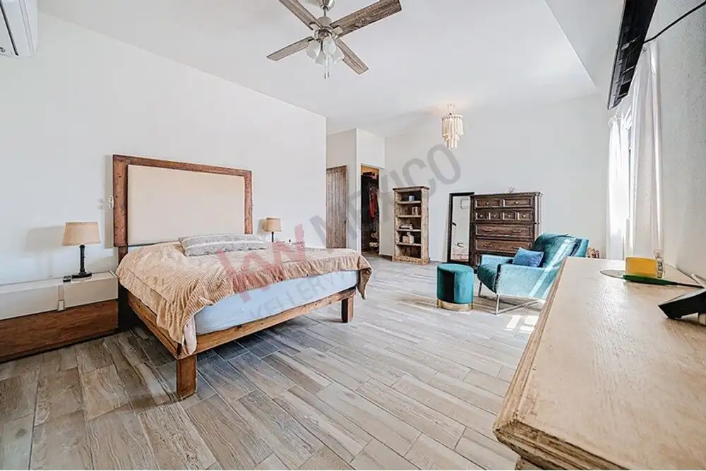 Spacious bedroom with modern decor, wooden furniture, and natural light in a beautiful San Miguel de.