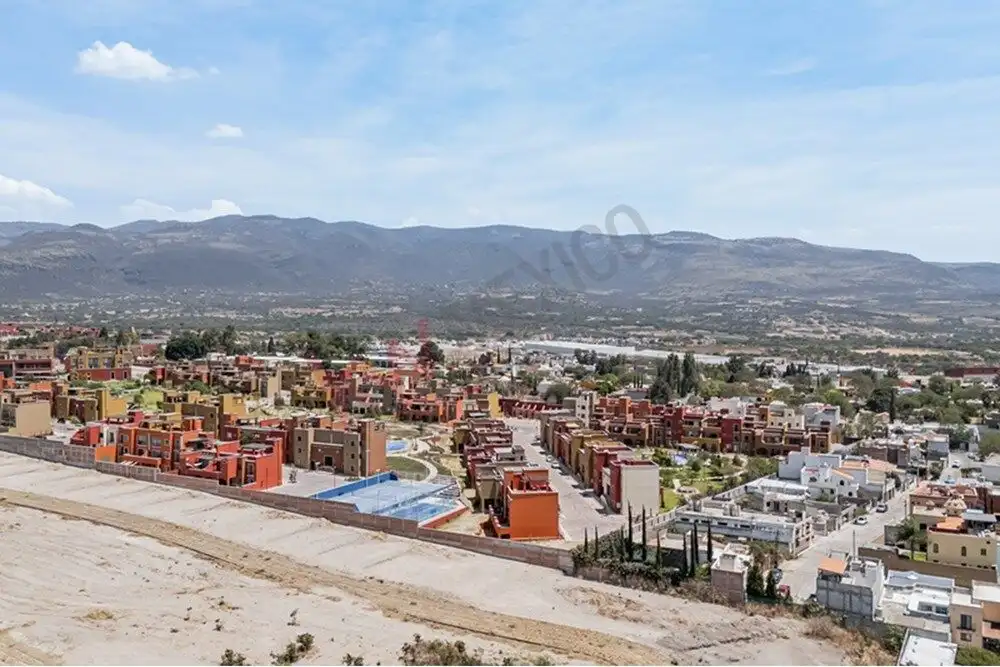 Panoramic view of San Miguel de Allende with colorful houses and mountain backdrop.