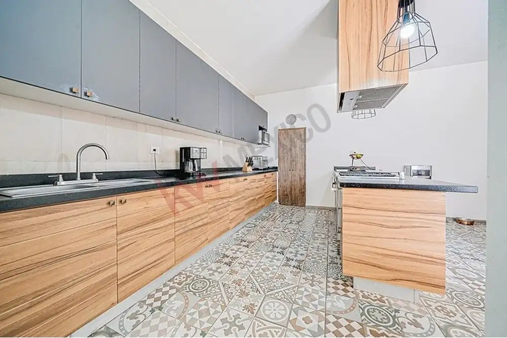 Spacious kitchen with sleek gray cabinets and wooden accents in a modern home.