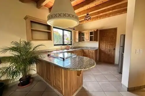 Spacious kitchen with wooden cabinets and granite countertops in Rancho Los Labradores.