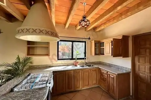 Kitchen with wooden ceiling beams and modern cabinetry in Rancho Los Labradores.