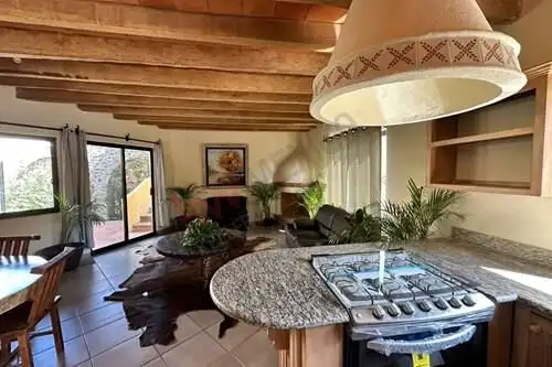Spacious living room with rustic wooden ceiling and large windows in Rancho Los Labradores.