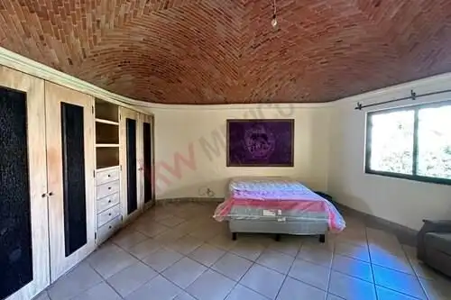 Spacious bedroom featuring a wooden ceiling, large window, and built-in wardrobe in a Rancho Los Lab.