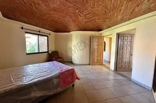 Spacious bedroom with wooden ceiling and large window in Rancho Los Labradores villa.