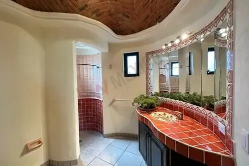Spacious bathroom with unique curved design and red tile accents in Rancho Los Labradores.