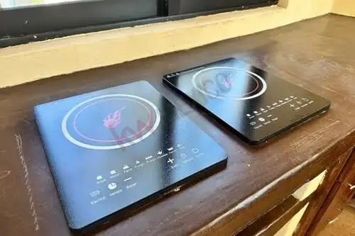 Electric cooktops with digital controls and sleek black glass surface.