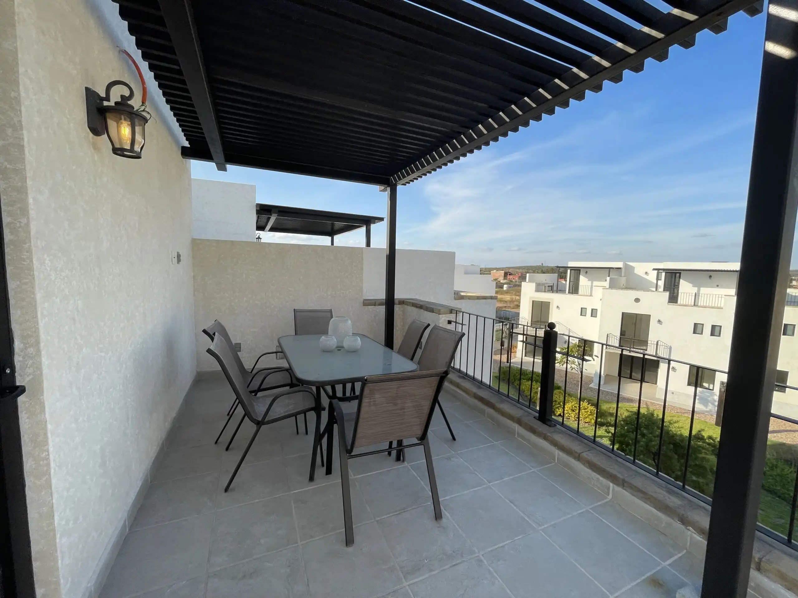 Outdoor dining space on a balcony with a table and chairs, overlooking San Miguel de Allende.