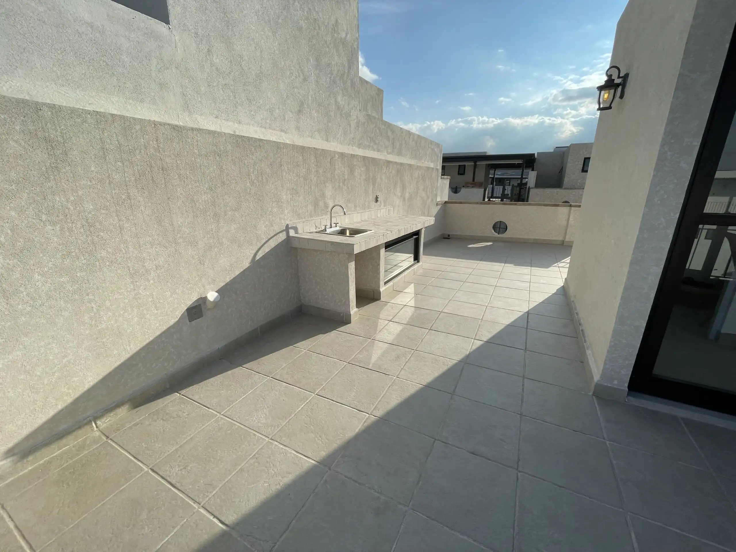 Outdoor rooftop terrace with sink and cityscape view in San Miguel de Allende.