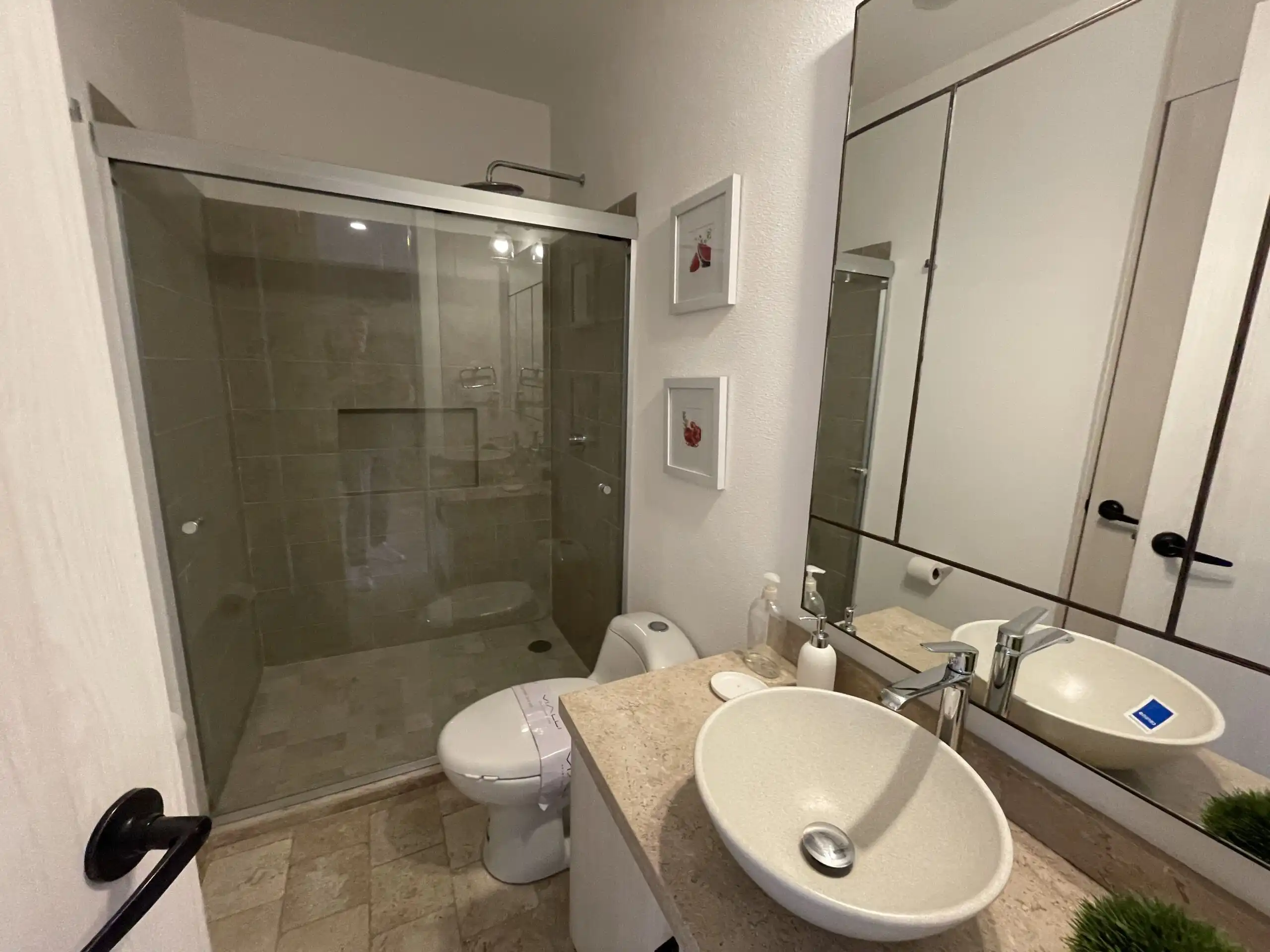 Luxury Bathroom with Modern Fixtures and Shower Area Modern bathroom featuring a glass-enclosed shower, stylish sink, and contemporary decor in a high-en.