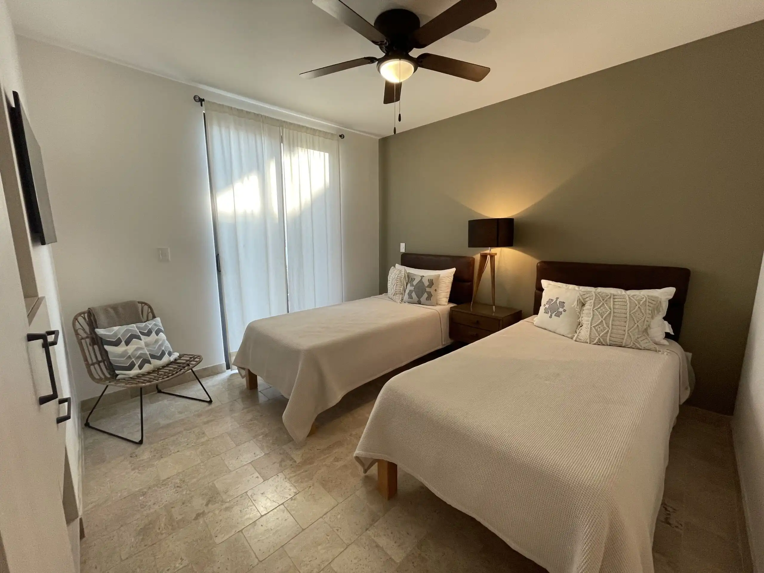 Luxury Home Bedroom with Pool View in San Miguel de Allende Modern bedroom featuring two beds, a ceiling fan, and natural light in a high-end San Miguel de Alle.