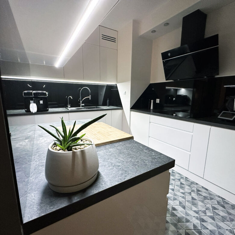 Modern 2-bedroom apartment kitchen in Warsaw with sleek black and white design.