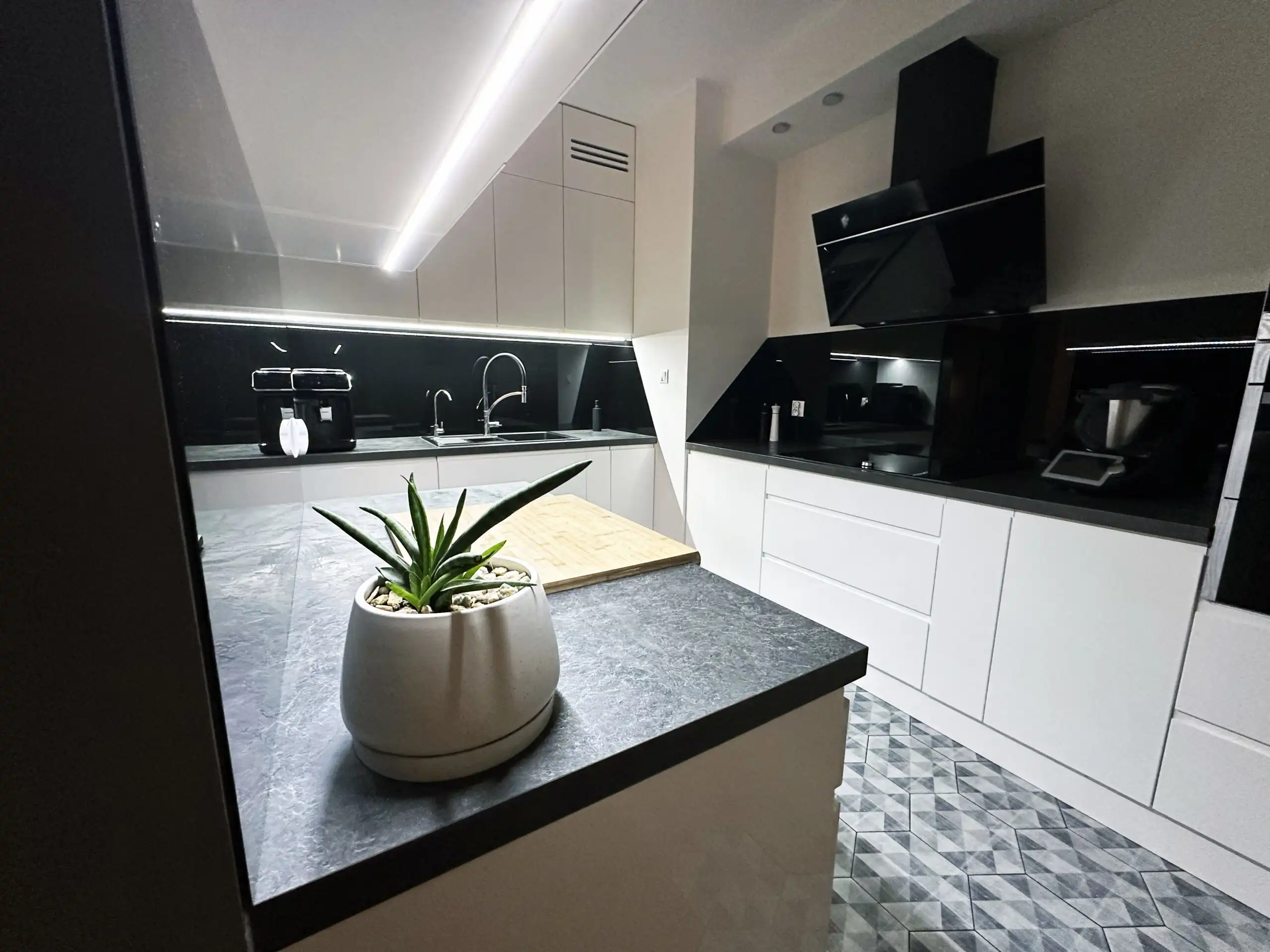 Modern 2-bedroom apartment kitchen in Warsaw with sleek black and white design.