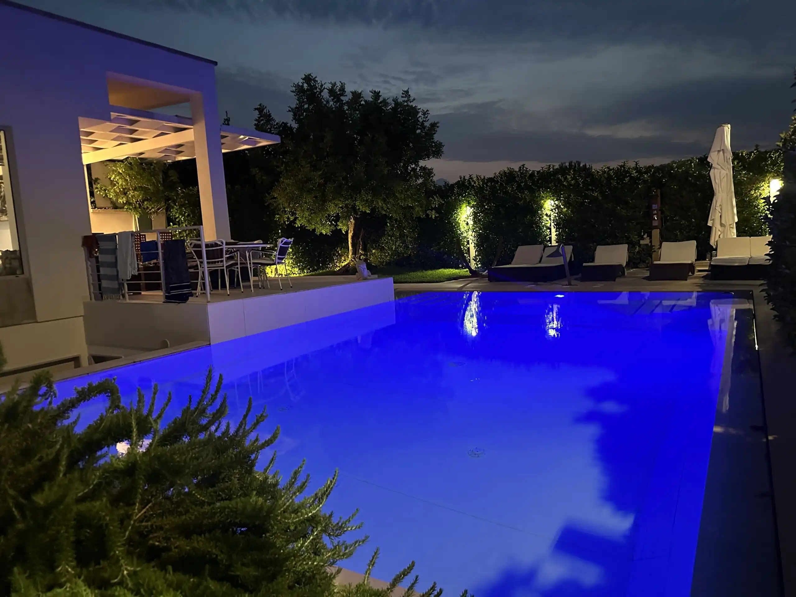 Luxury villa with illuminated pool and panoramic views near the Adriatic Sea.
