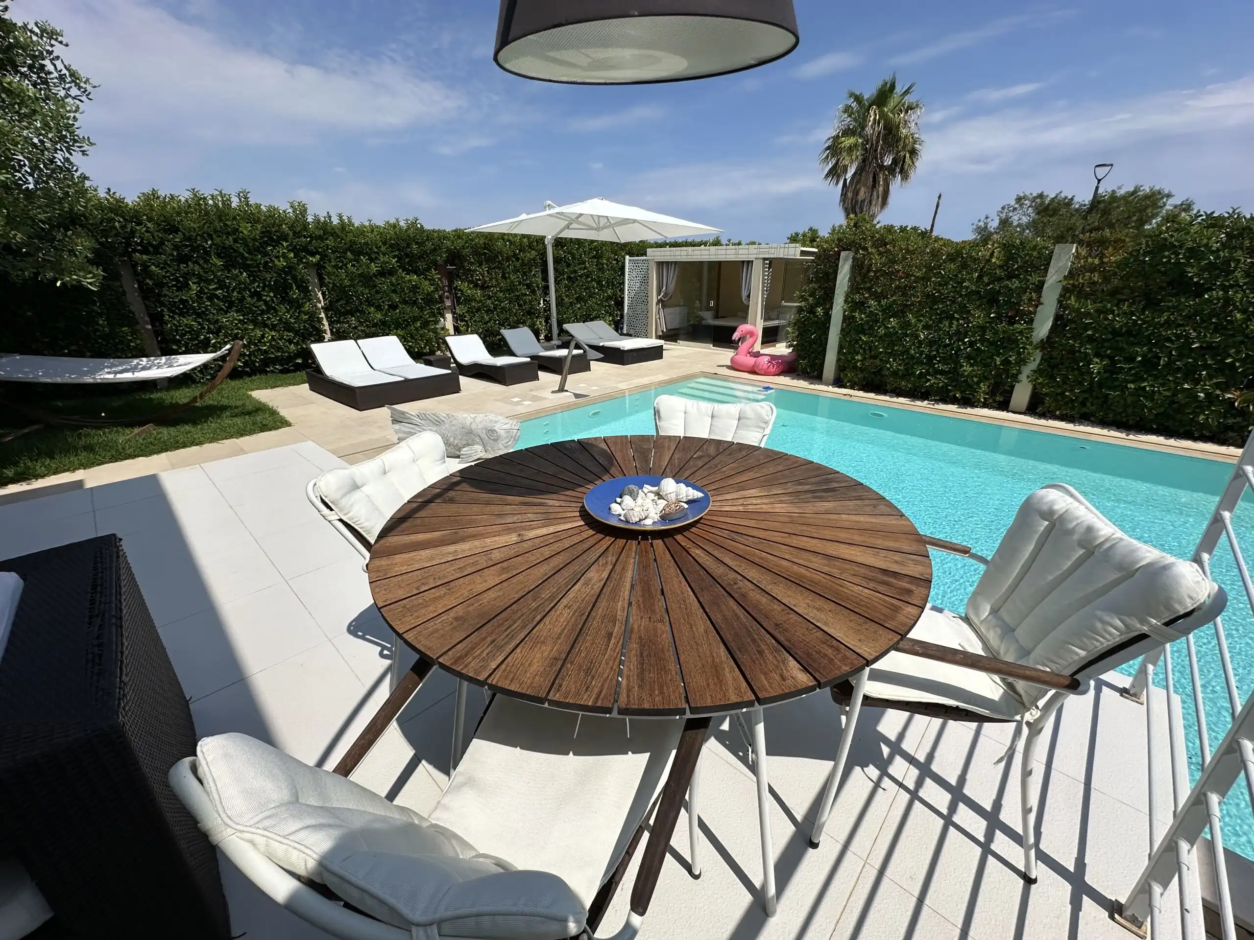 Beautiful outdoor pool area with sun loungers and a shaded dining space in Otranto, Puglia. Perfect.