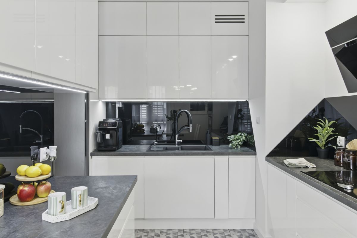Modern 2-bedroom apartment kitchen in Warsaw with sleek white cabinets and contemporary appliances.
