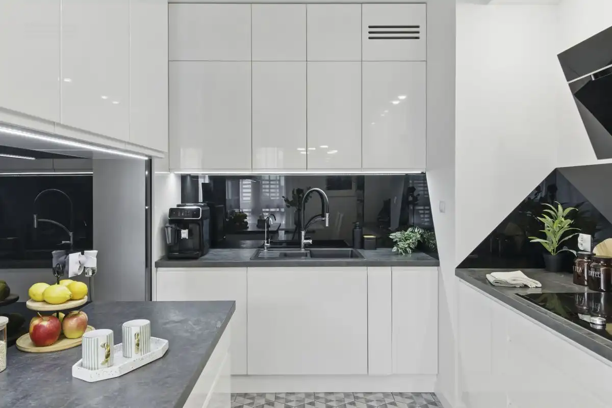 Modern 2-bedroom apartment kitchen in Warsaw with sleek white cabinets and contemporary appliances.