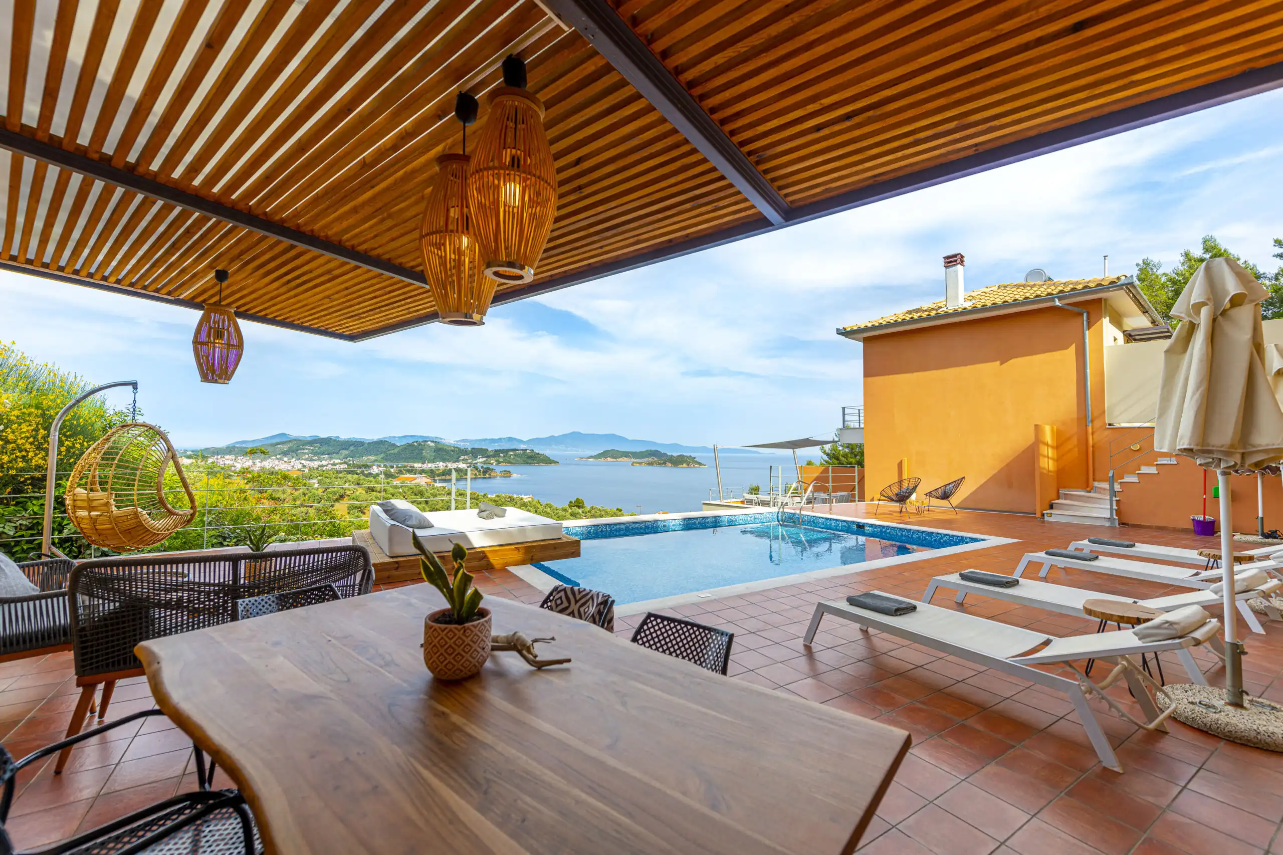 View villa complex for sale in Skiathos, Greece, with pool and spacious terrace overlooking the sea.
