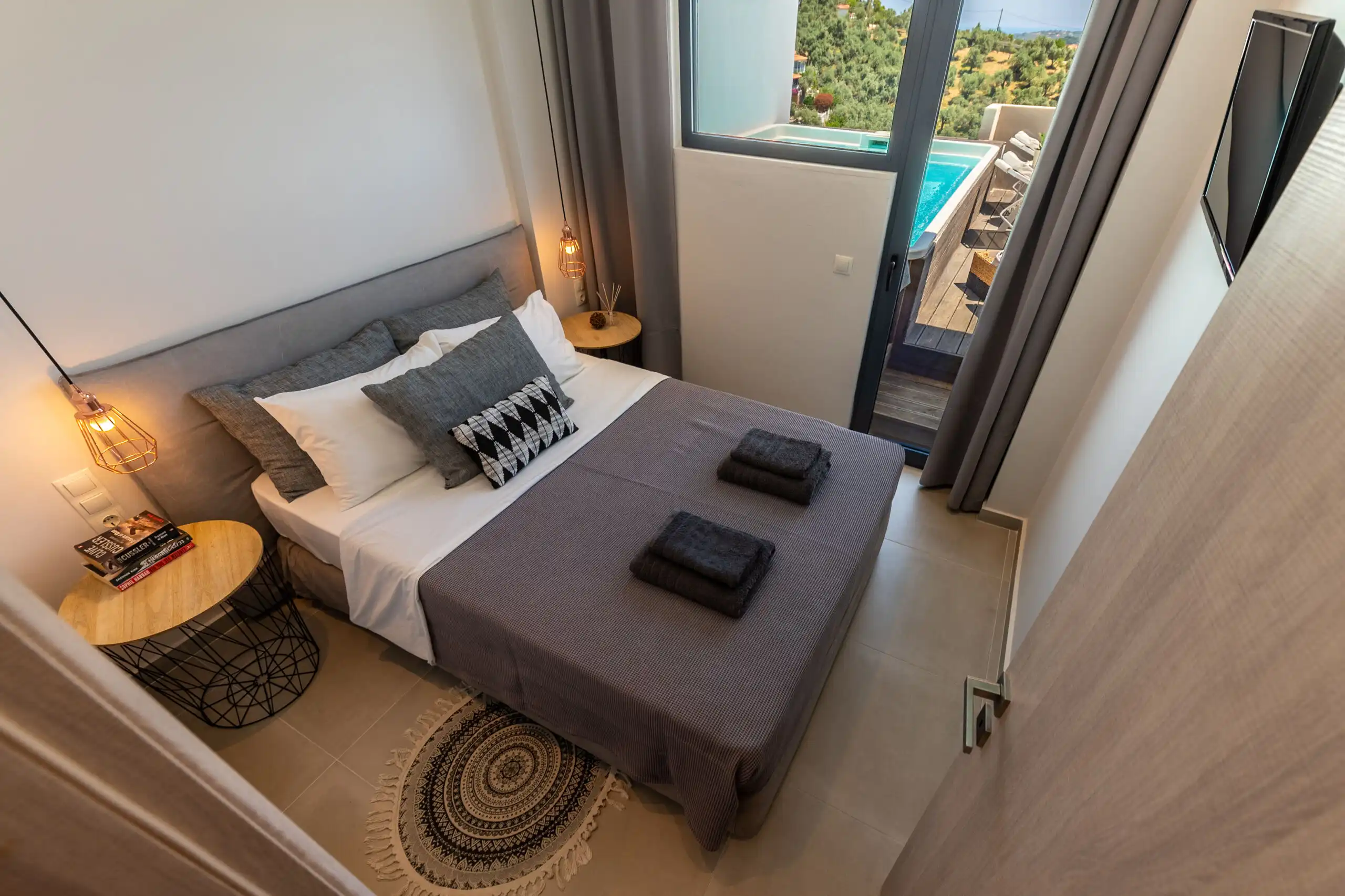 View bedroom in a luxury villa with stylish decor and balcony access in Skiathos, Greece.