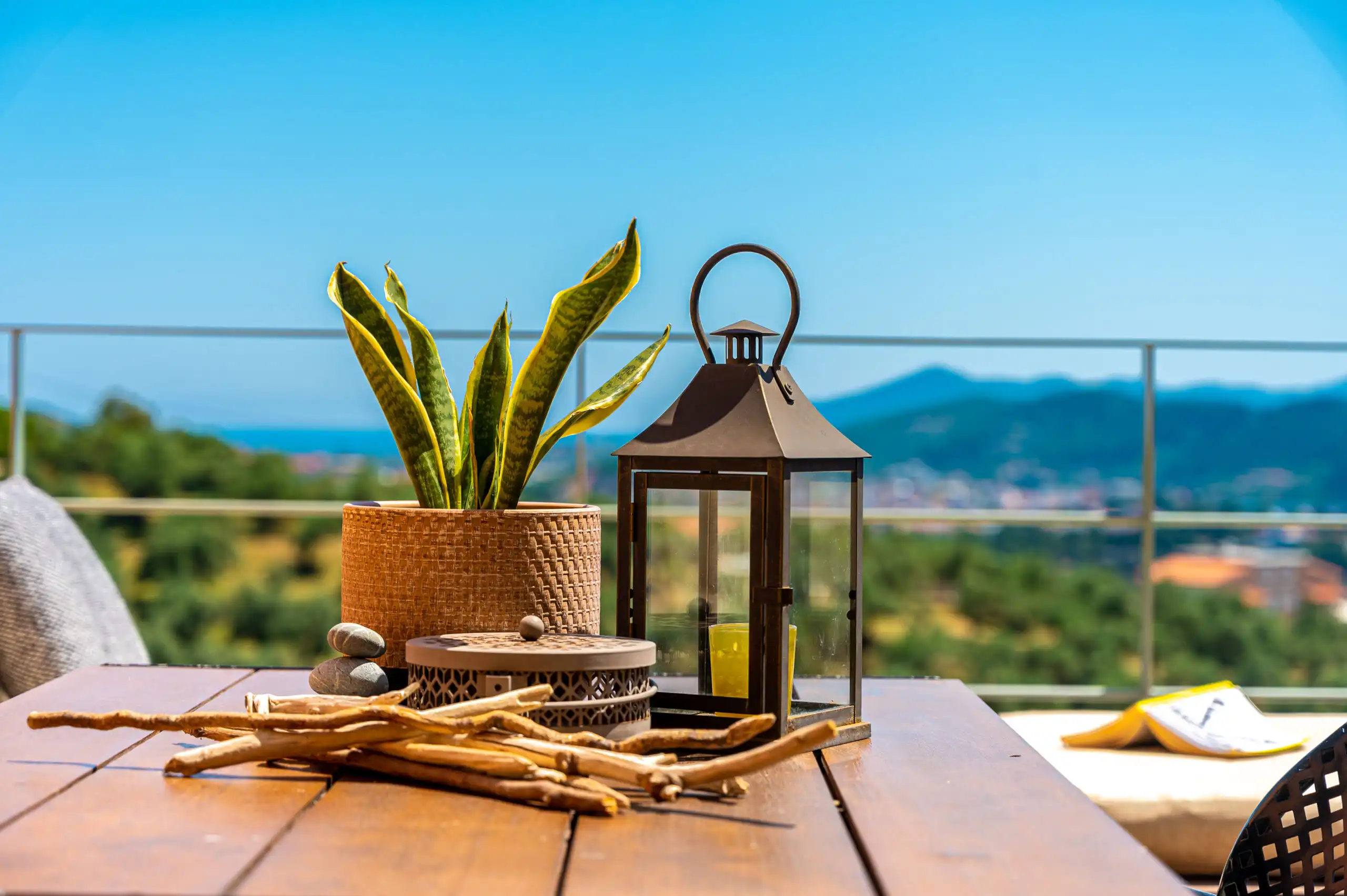 Beautiful outdoor terrace with sea view, potted plant, lantern, and decorative items in Skiathos, Gr.