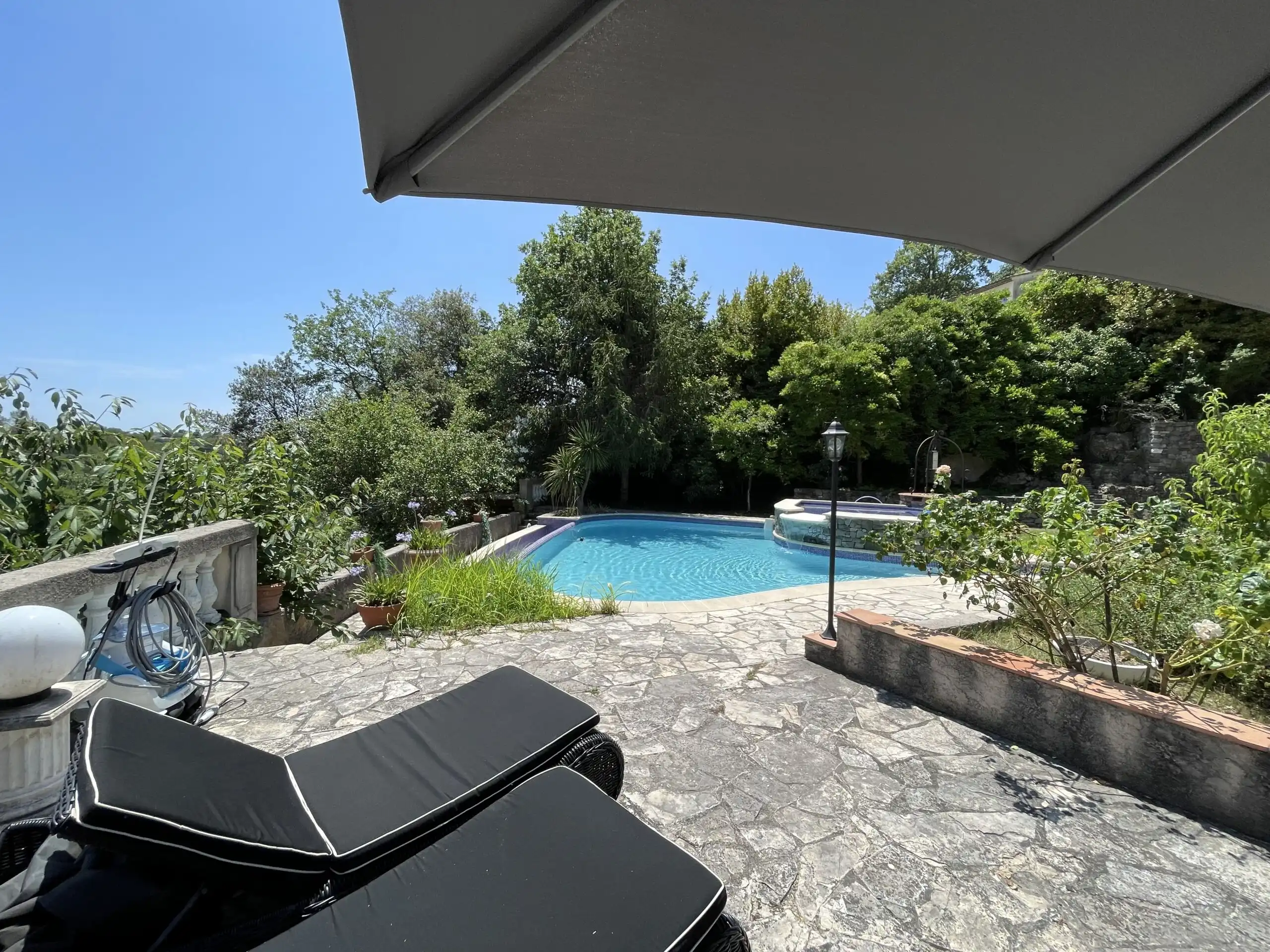 Pool area of a luxury family villa in Biot, featuring a private swimming pool surrounded by lush gar.