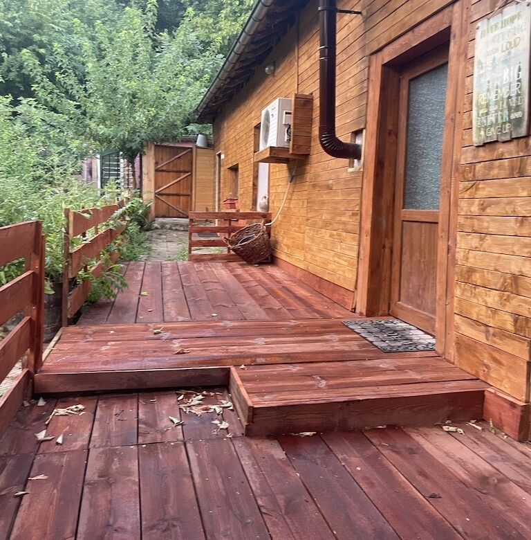 Wooden house exterior with deck and lush greenery in Traykovo.