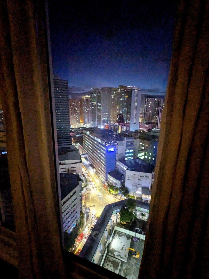 City view from Kroma Tower Manila apartment window at night.