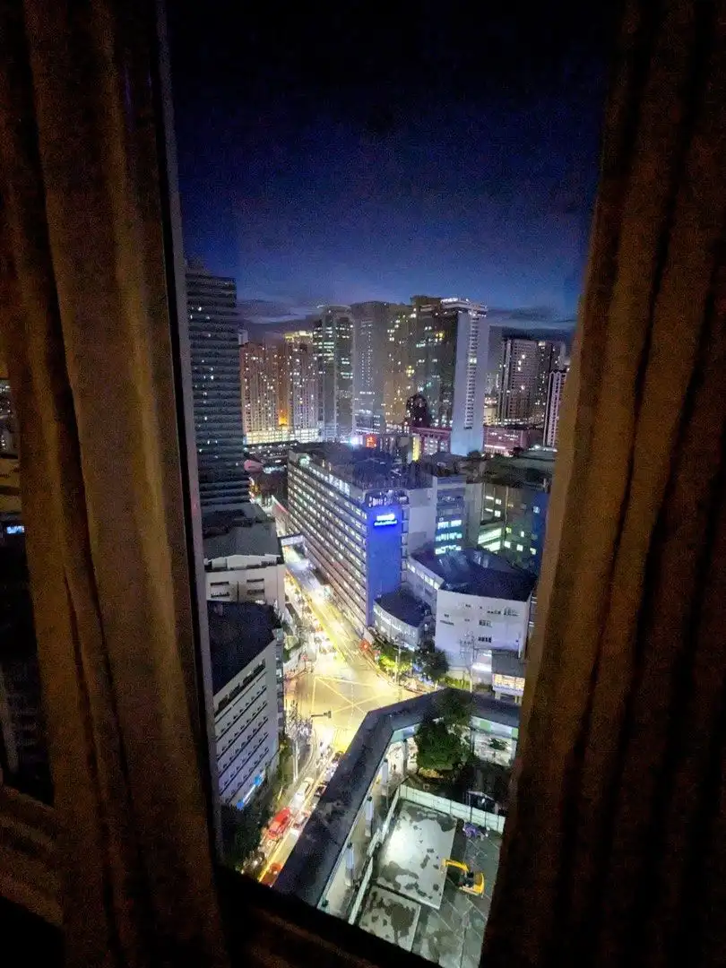 City view from Kroma Tower Manila apartment window at night.