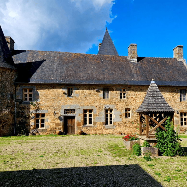 Le Manoir de Dougeru historic castle in Normandy, France, with lush gardens and classic architecture.