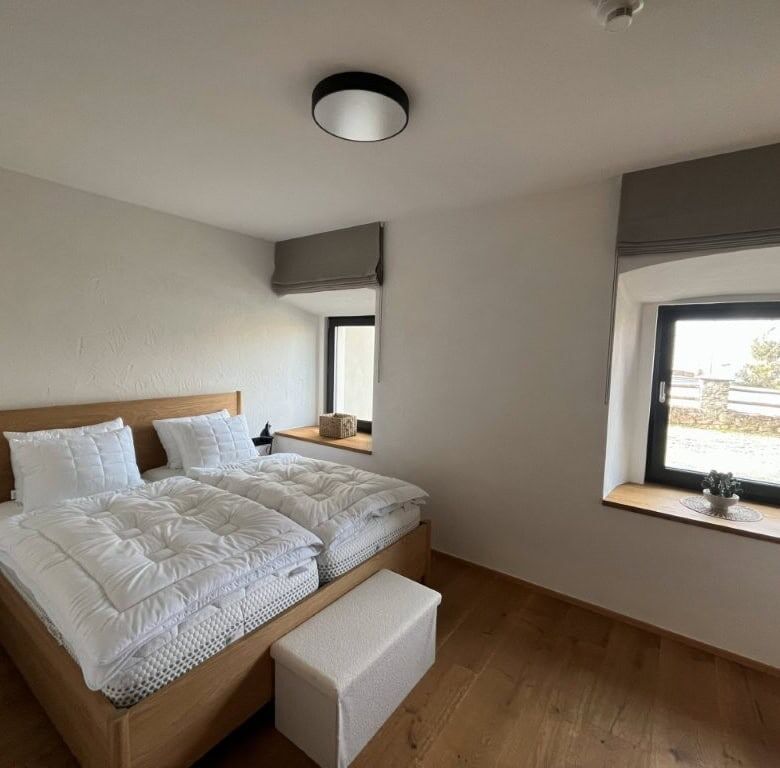 Spacious bedroom in a luxury apartment in Rattendorf with modern decor and natural light.