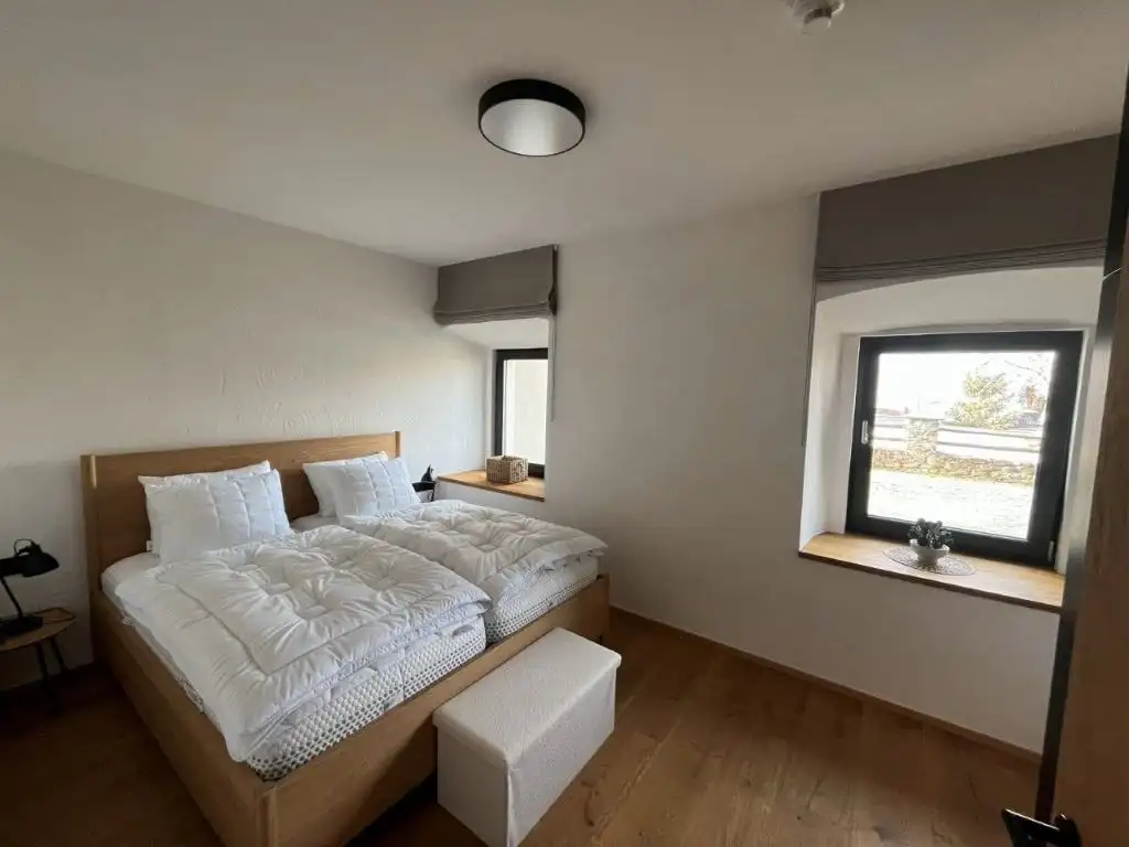 Spacious bedroom in a luxury apartment in Rattendorf with modern decor and natural light.