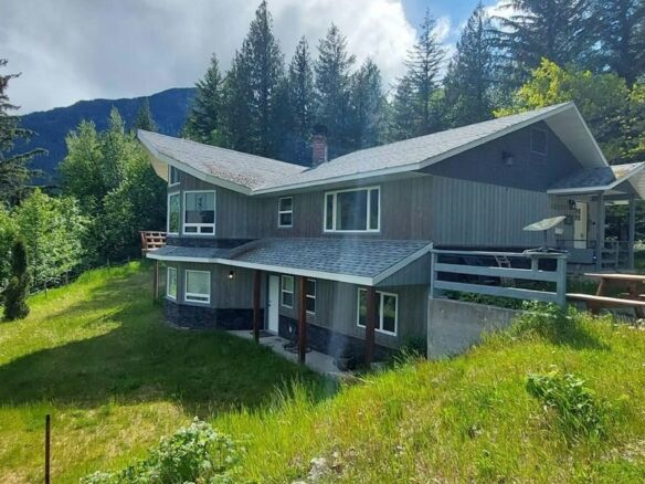 Beautiful 4-bedroom estate for sale in Bella Coola, British Columbia, surrounded by lush greenery an.