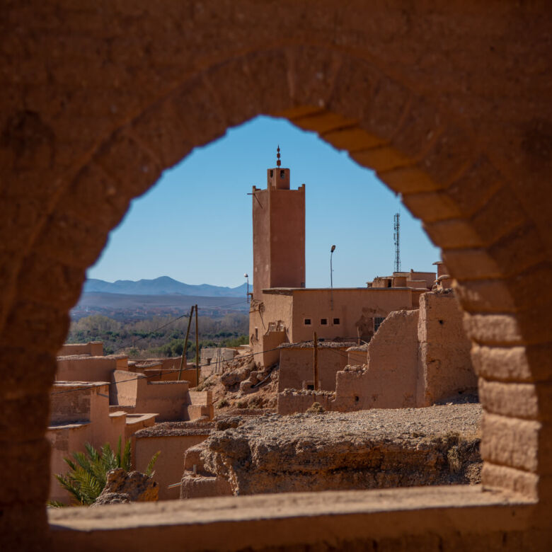 View of Kasbah Tiziri Hotel through an arched window in Imzough.