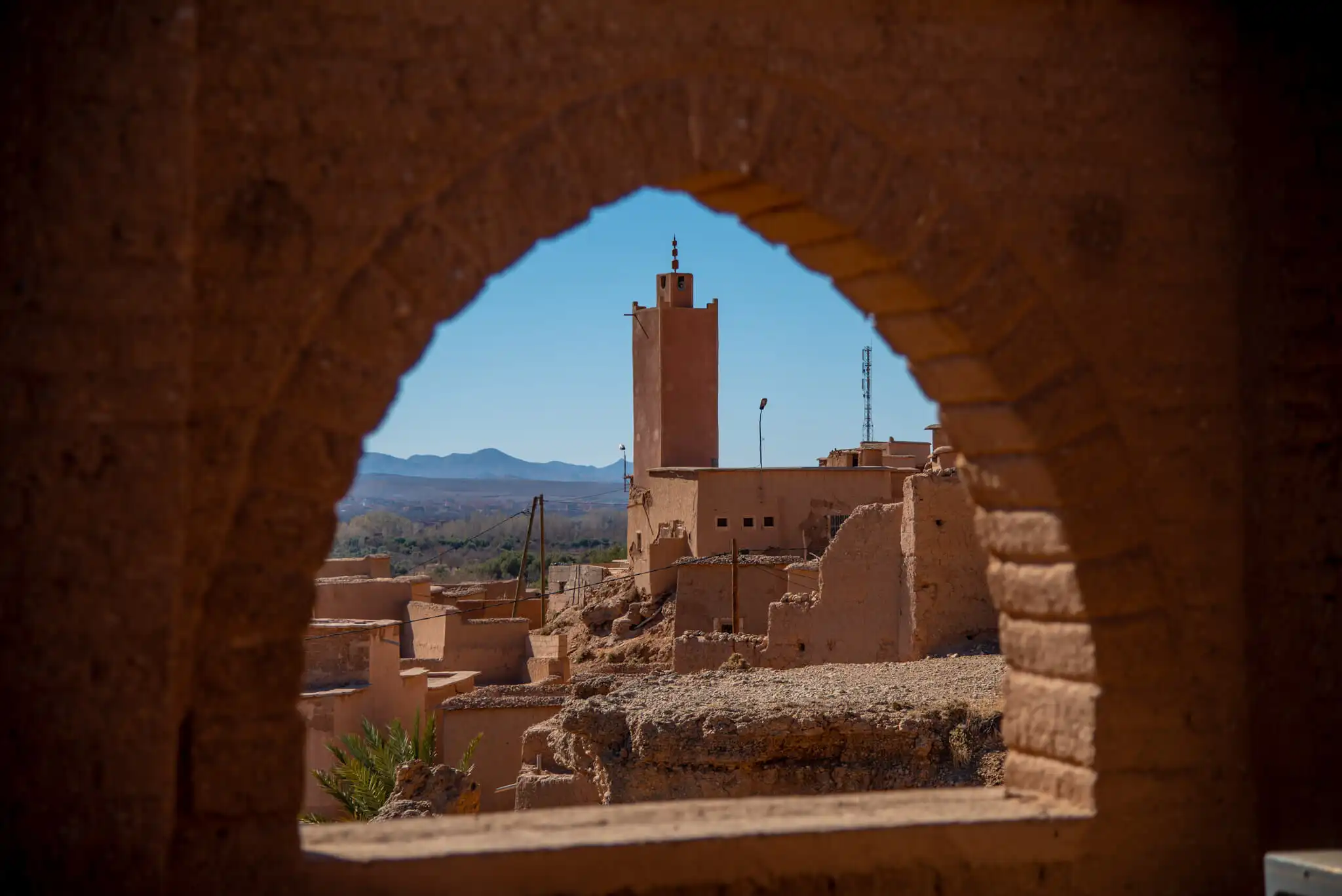 View of Kasbah Tiziri Hotel through an arched window in Imzough.