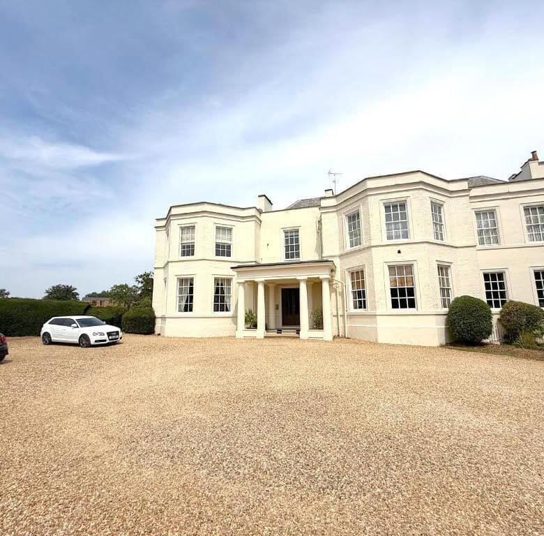 Elegant white 3-bedroom apartment with large windows and landscaped surroundings in Milton Keynes.