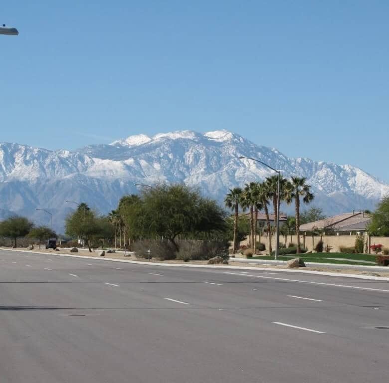 Beautiful view of snow-capped mountains behind a residential street in Indio, California.