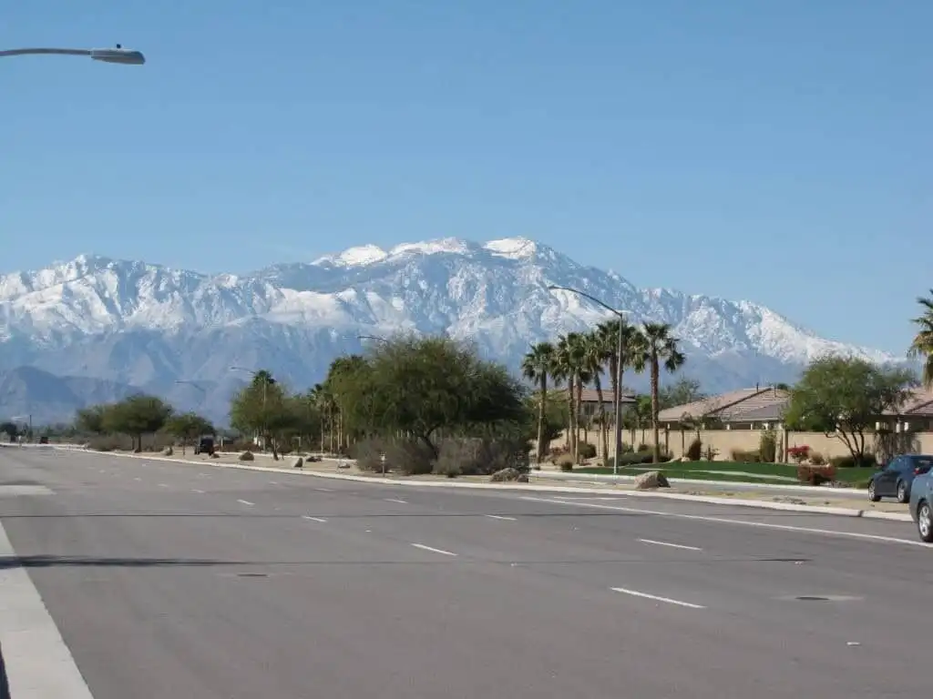 Beautiful view of snow-capped mountains behind a residential street in Indio, California.