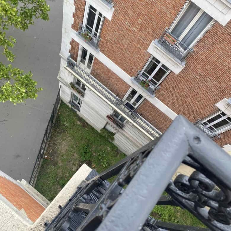 Elegant 1-bedroom apartment view in Paris with classic architecture and balcony details.