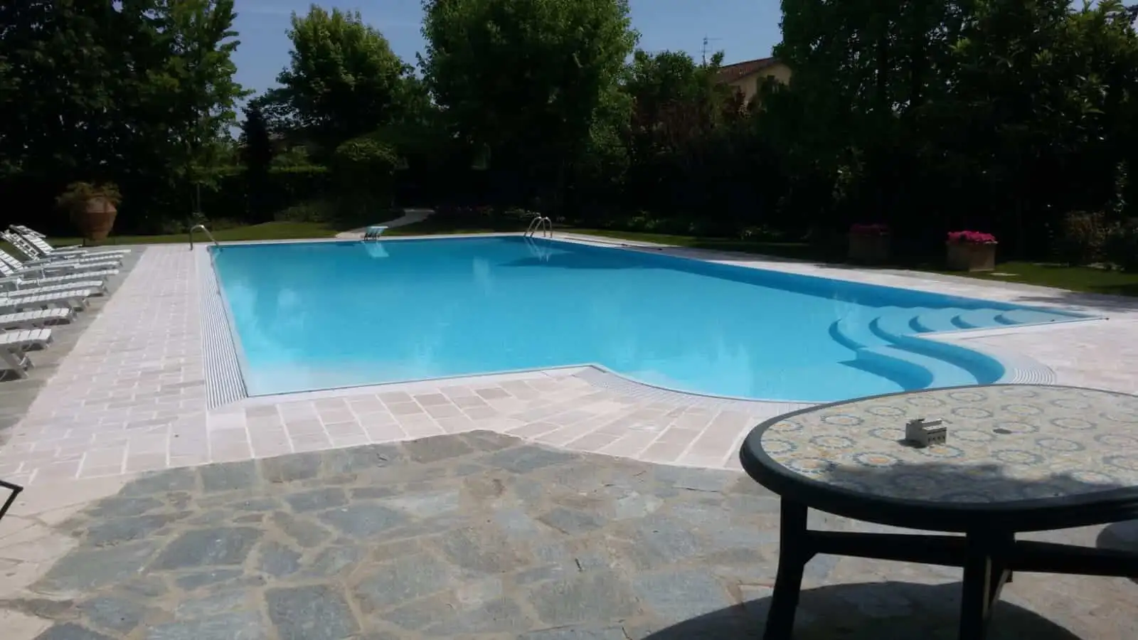 Spacious outdoor pool area at a luxury 8-bedroom estate in Forli, ideal for relaxing and entertainin.