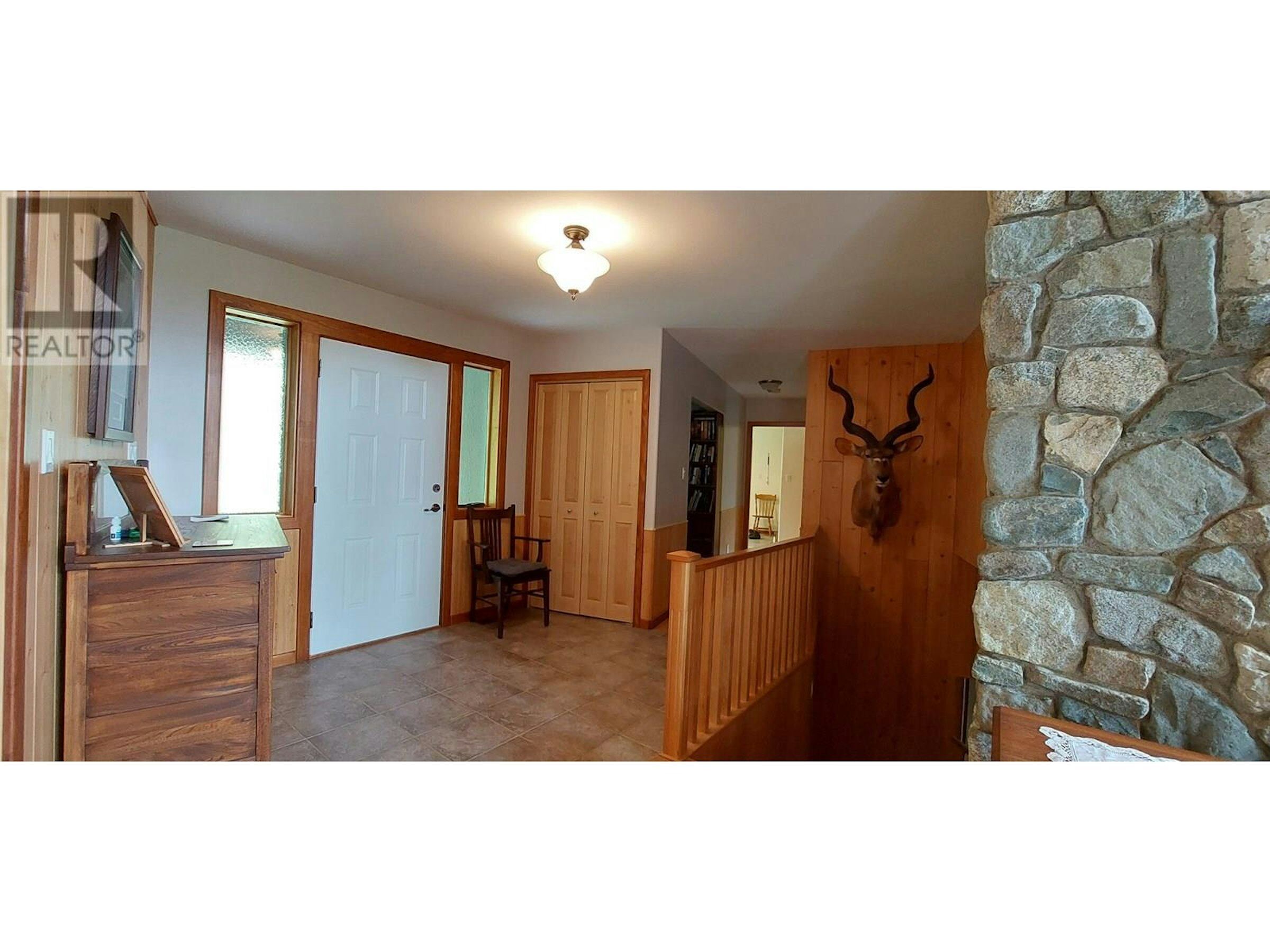 Cozy Entrance Hall in Bella Coola Entrance hall with wooden accents and stone wall feature in Bella Coola estate.