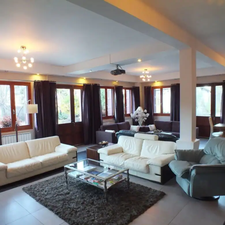 Spacious living room with modern furniture in the La Chataigneraie Gite Complex, perfect for relaxin.