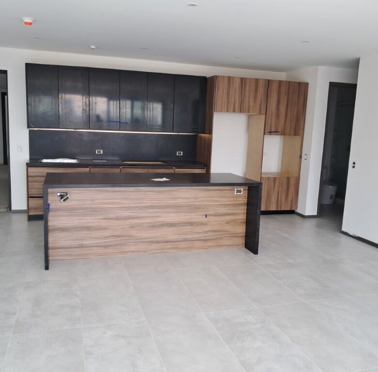 Contemporary kitchen with sleek cabinets and island in Tijuana luxury condo.