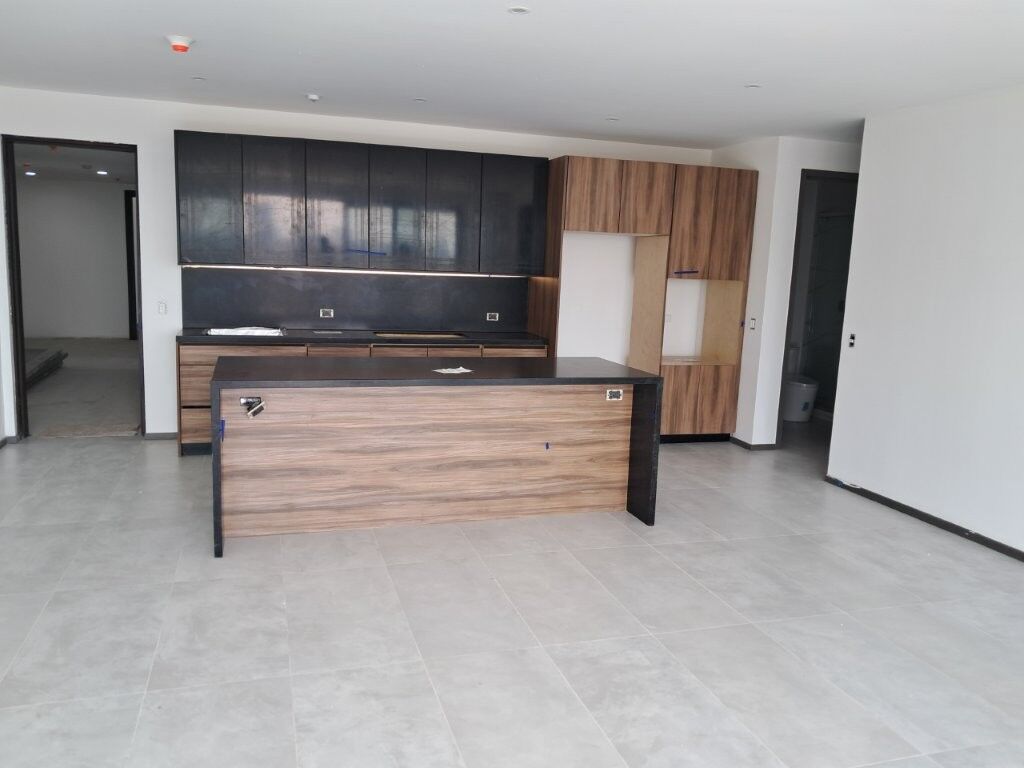 Contemporary kitchen with sleek cabinets and island in Tijuana luxury condo.