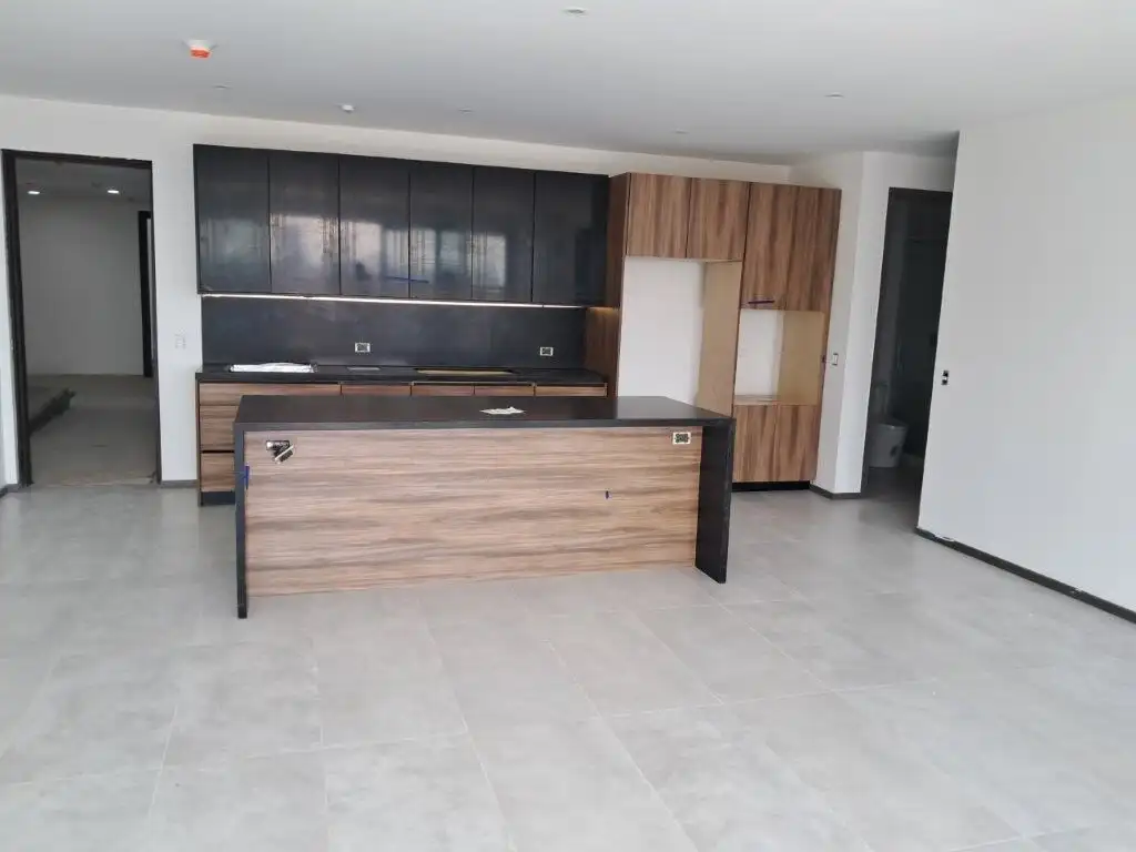 Contemporary kitchen with sleek cabinets and island in Tijuana luxury condo.