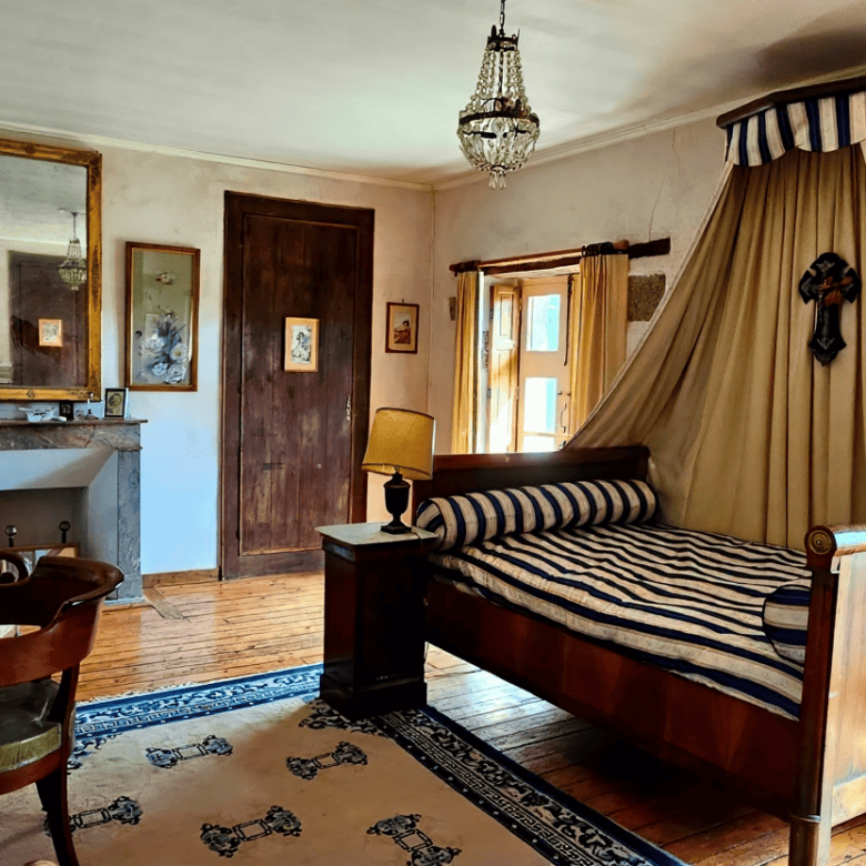 Elegant bedroom with a canopy bed and vintage decor in Le Manoir de Dougeru.