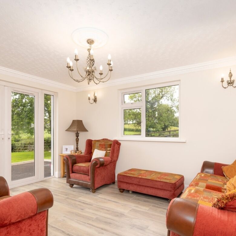 Bright living room featuring large windows overlooking lush greenery in Cosbystown Enniskillen.