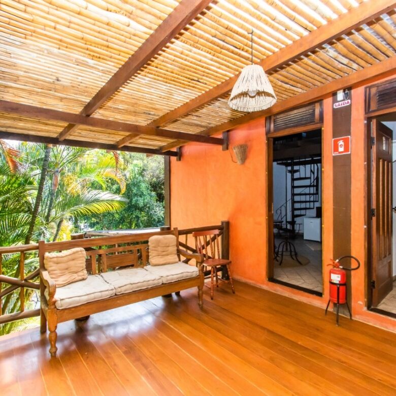 Cozy hotel terrace with wooden furniture and tropical greenery in Ilhabela.